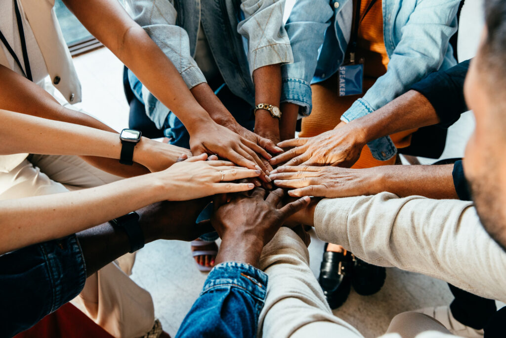 Diverse group of hands joined together, representing teamwork and unity. Symbolizes cooperation, collaboration, and the power of collective effort.